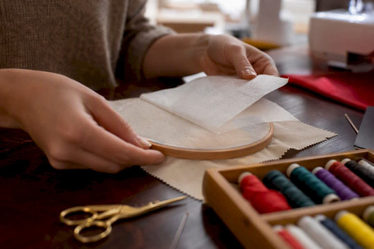 Hands stretching fabric with stabilizer in embroidery hoop