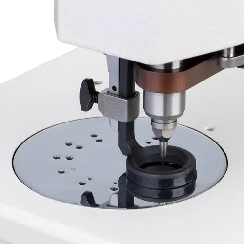 Industrial sewing machine single-needle area with presser foot and round throat plate on white body