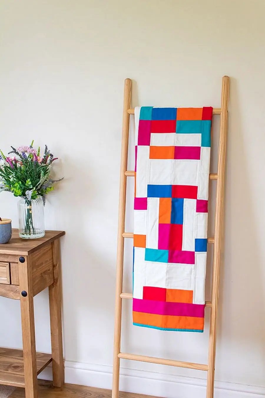Crafters Companion Threaders Shape Creator cutting mats, vibrant patchwork quilt on a wooden ladder