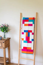 Crafters Companion Threaders Shape Creator cutting mats, vibrant patchwork quilt on a wooden ladder