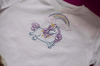 Threaders embroidery transfer sheets, fantasy design on white shirt featuring a colorful unicorn under a rainbow