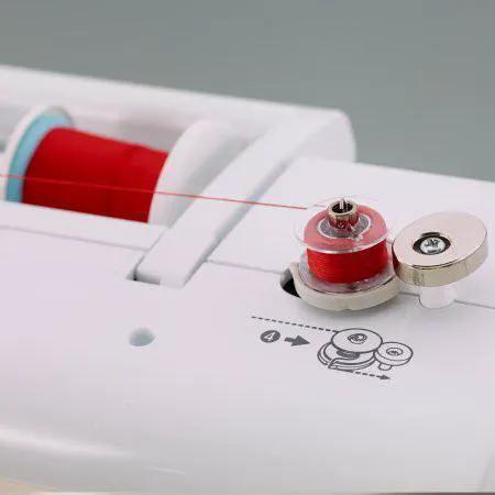 Brother sewing and embroidery machine close-up: white unit with red thread spool and tension wheel