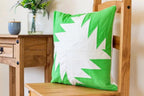 Threaders cushion on a wooden chair featuring a bright green and white geometric pattern