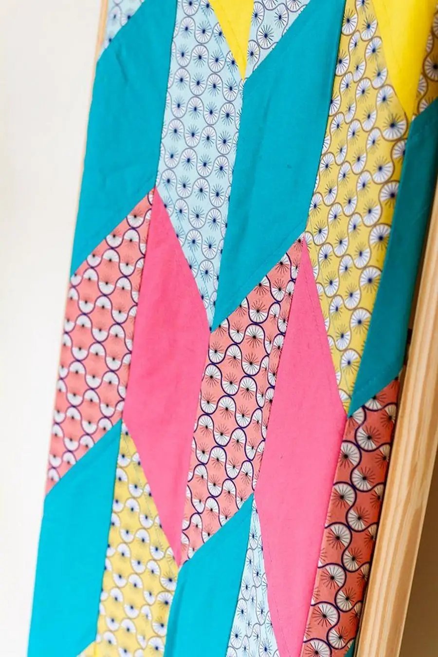 Threaders cutting mats featuring colorful fabric strips in teal, pink, and yellow arranged in a geometric mosaic