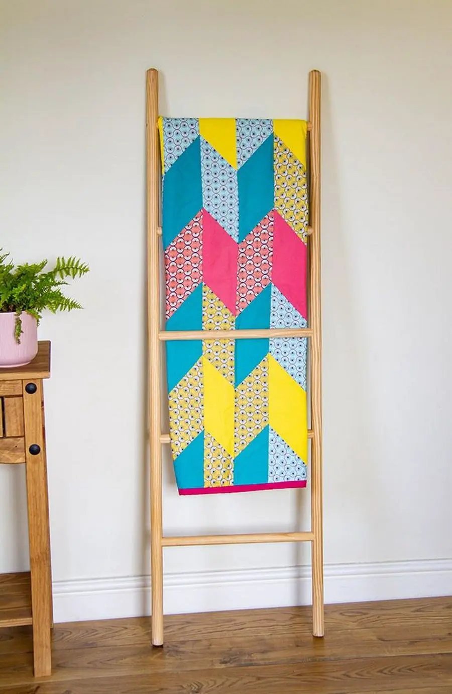 Crafters Companion Threaders Shape Creator cutting mats on a wooden stand with bright geometric fabric panels