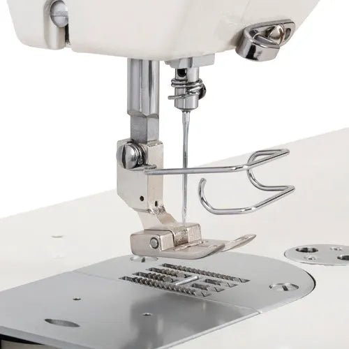 Consew industrial sewing machine 199RB single-needle drop-feed with table and motor, silver body.