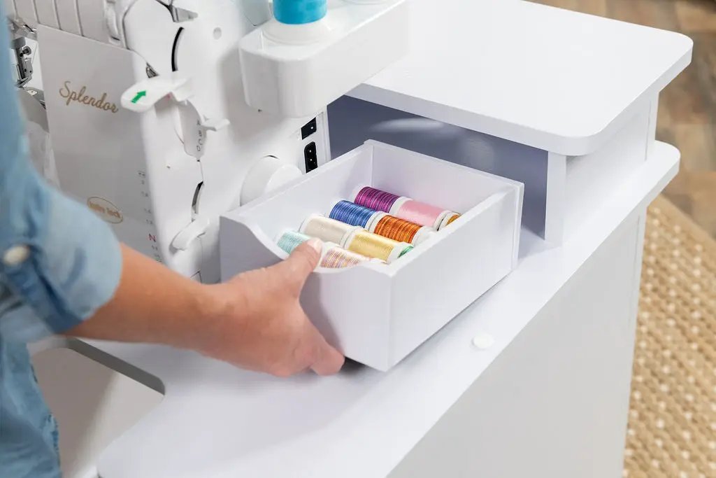 Koala Serger Studio white sewing machine extension table with a drawer of colorful thread spools