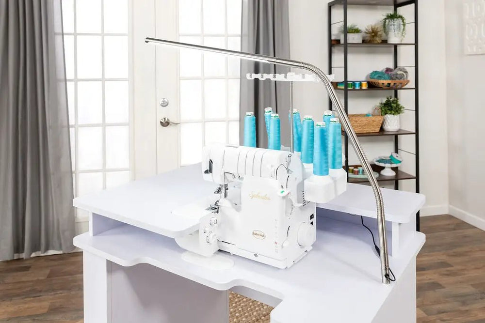 Koala Serger Studio on white sewing extension table with six blue thread spools.