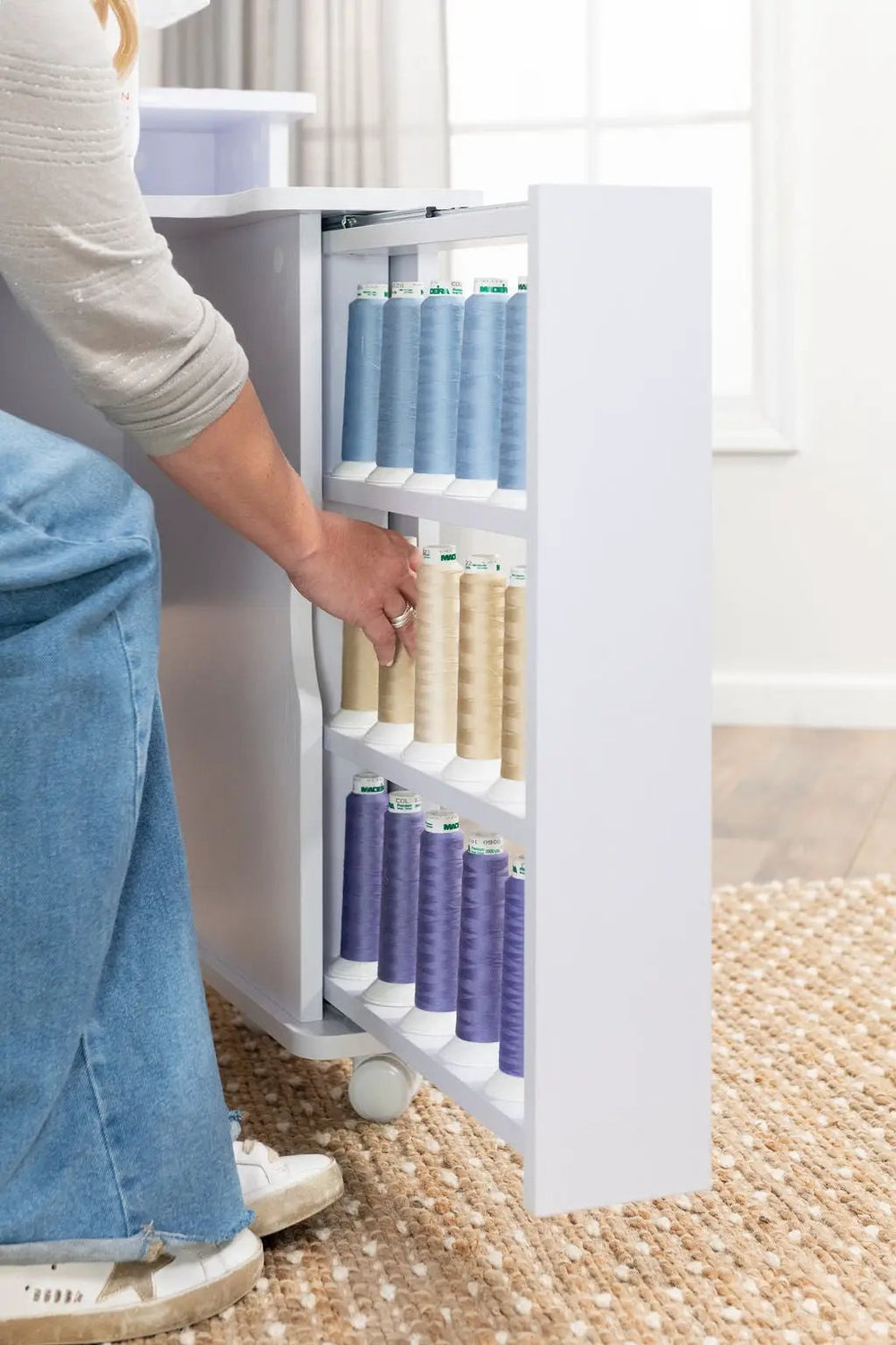 Koala Serger Studio table with white frame and thread-spool rack of blue, beige, and purple spools