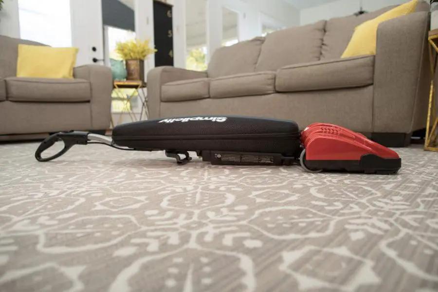 Simplicity S10CV Freedom cordless upright vacuum with red powerhead on carpet.