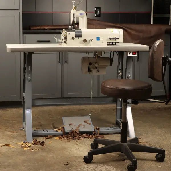 Consew DCS-S4 skiving machine, beige, on assembled table with servo motor in workshop.