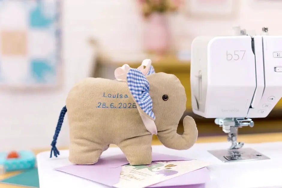 Bernette B57 sewing machine by Bernina; white machine with beige plush elephant nearby