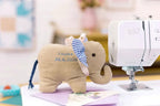 Bernette B57 sewing machine by Bernina; white machine with beige plush elephant nearby