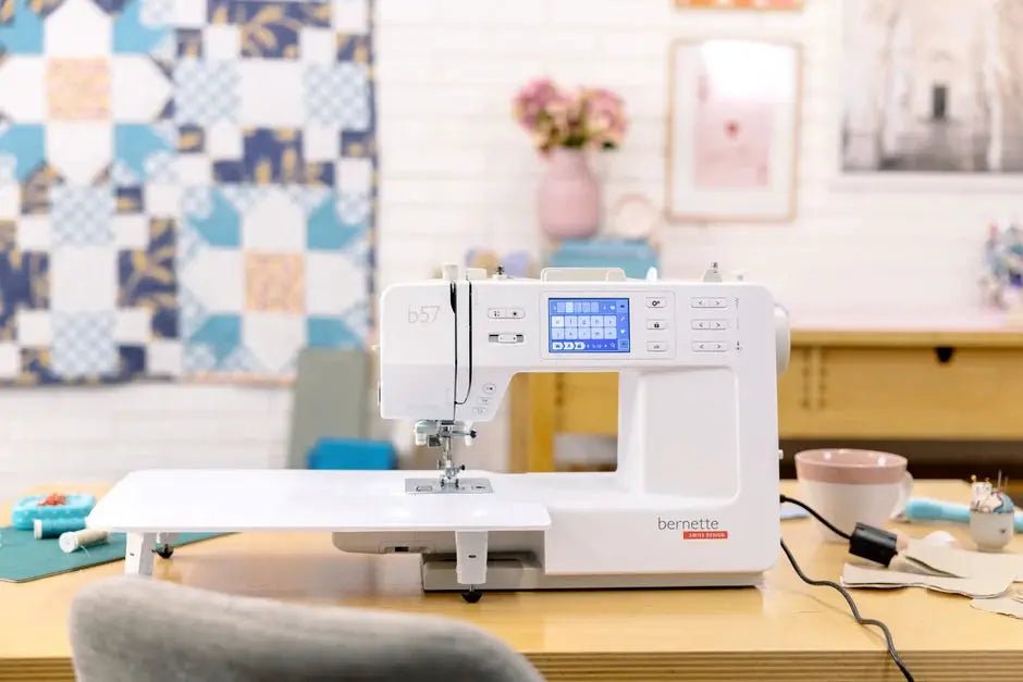 Bernette B57 sewing machine, white, on a wooden table in a sewing room.