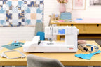 Bernette B59 Sewing and Embroidery machine, white with digital display on a wooden desk