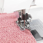 Viking changeable 1/4-inch guide foot on sewing machine with pink patterned fabric, Husqvarna Viking