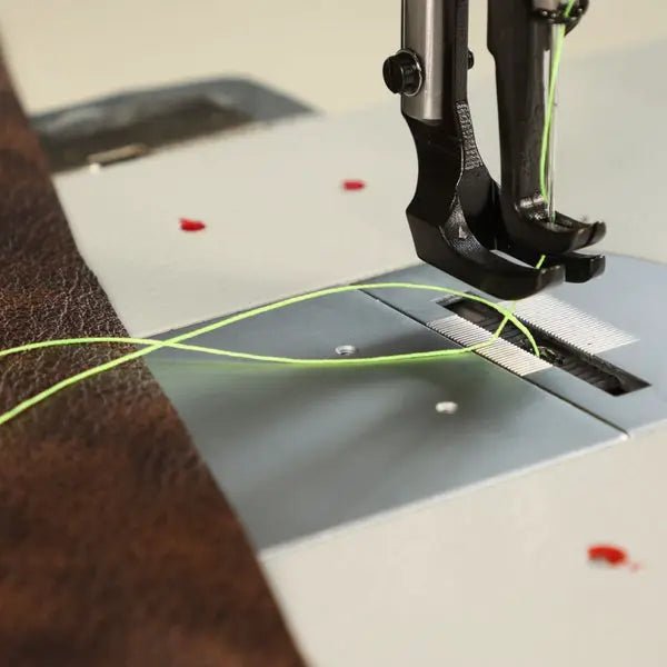 Consew 206RB-5 walking-foot upholstery sewing machine on a table with neon-green thread under the presser foot.