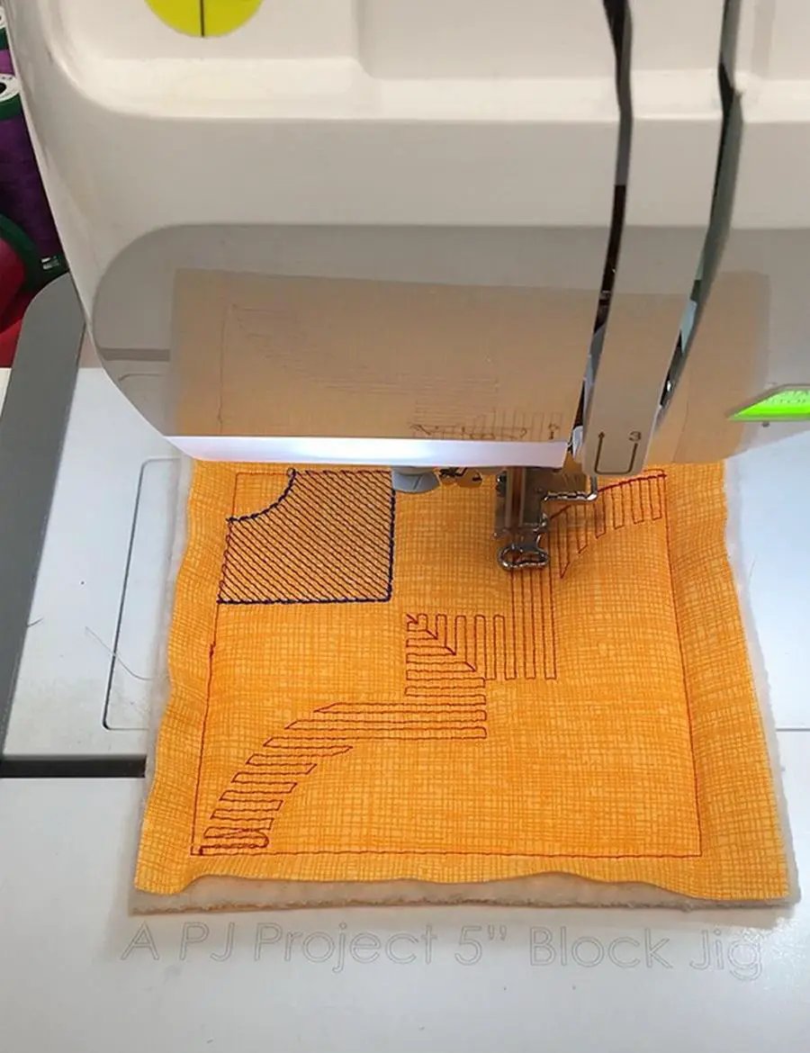 DIME Monster Block Maker single-needle hooping aid on orange fabric under a sewing machine