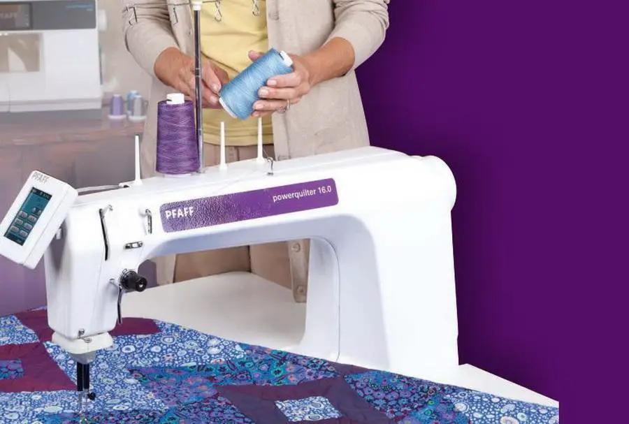 Pfaff PowerQuilter 16.0 long-arm quilting machine; white body with purple label, thread spools, quilt fabric beneath.