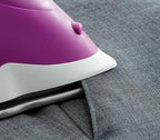 Oliso Ultra-Precision Steam Iron TG1100-P purple iron with white soleplate on denim fabric.