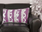 Throw pillow with purple and gray striped pattern on a black leather sofa.