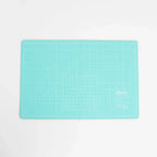 Cutting mat Sallie Tomato A3 foldable in turquoise with grid lines and logo