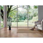 Dyson AM07 Tower Fan, white bladeless model, in a bright living room.