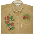 Anita Goodesign Northwoods embroidery design on tan button-down shirt with pinecone motifs