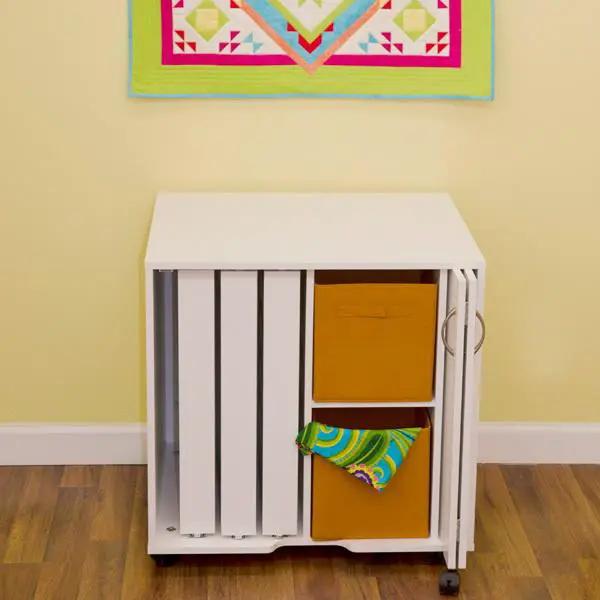 Arrow Mod Thread Cabinet in white with vertical slat doors and orange drawers on wheels.