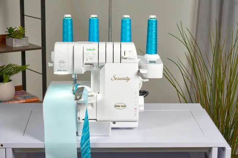 Baby Lock Serenity 4-thread serger, white machine with turquoise thread spools on a table