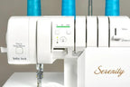 Baby Lock Serenity 4-Thread Serger sewing machine, white body with blue thread spools on top.