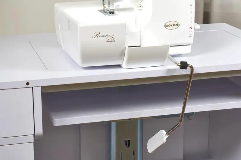 Baby Lock Serenity 4-Thread Serger sewing machine on white table with foot pedal.
