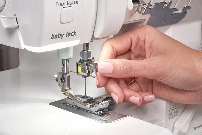 Baby Lock Serenity 4-Thread Serger sewing machine, white body, hand threading the needle.