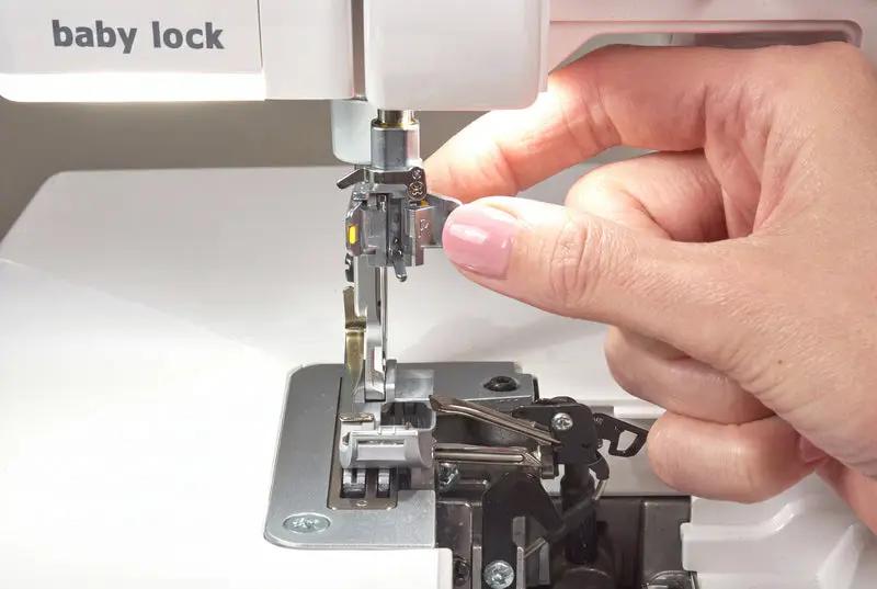 White Baby Lock Serenity 4-Thread Serger sewing machine close-up with hands threading.