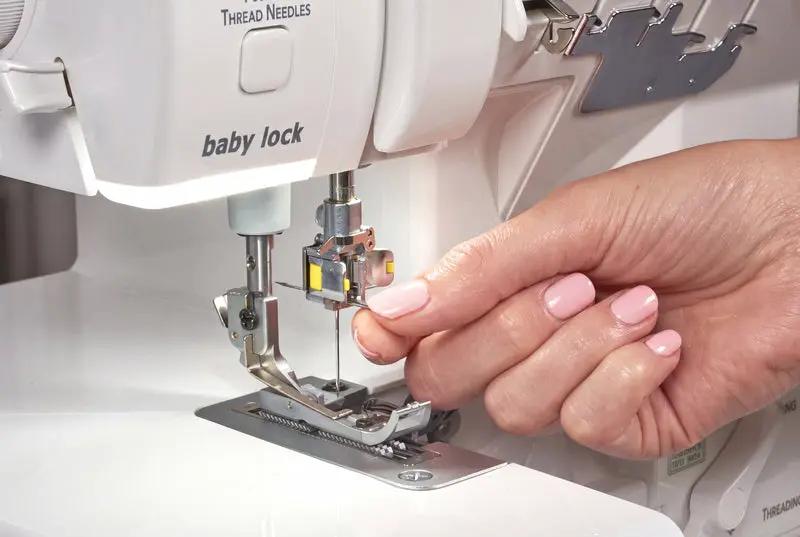 Baby Lock Serenity 4-Thread Serger sewing machine with white finish and a hand guiding fabric near the presser foot