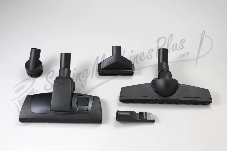 The Bank Robber Canister Vacuum in black with floor nozzle, brush tool, crevice tool, and small nozzle attachments