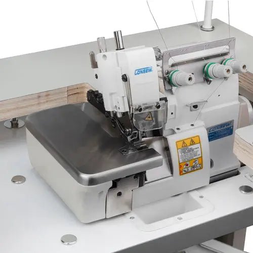 Consew CM793 serger with assembled table and servo motor; white industrial overlock with green thread spools.
