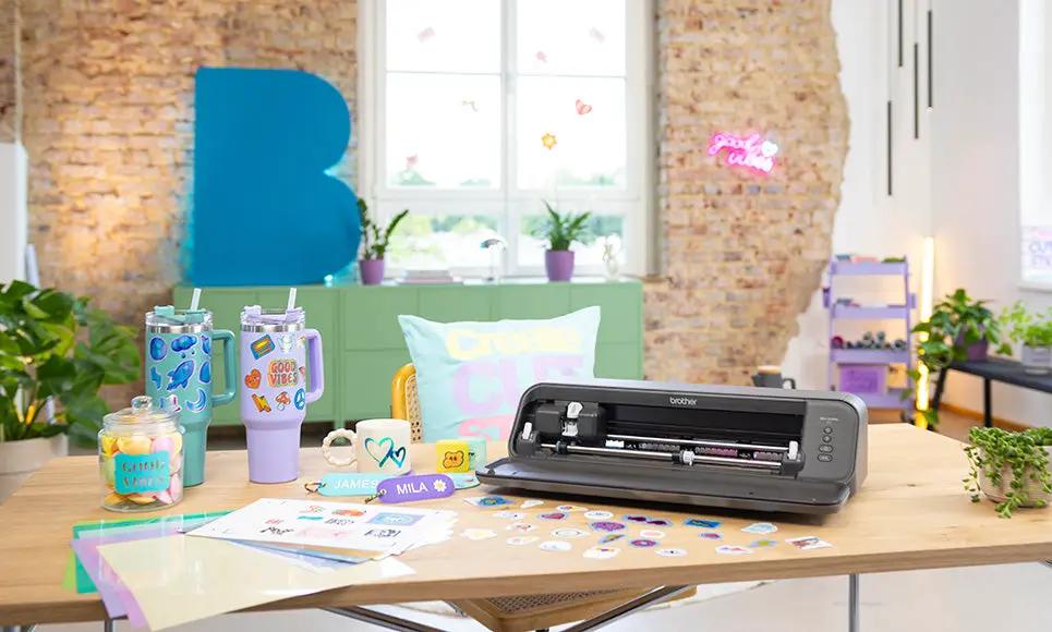 Brother Bellissimo CT1 cutting machine in dark gray on a wooden craft table with colorful stickers