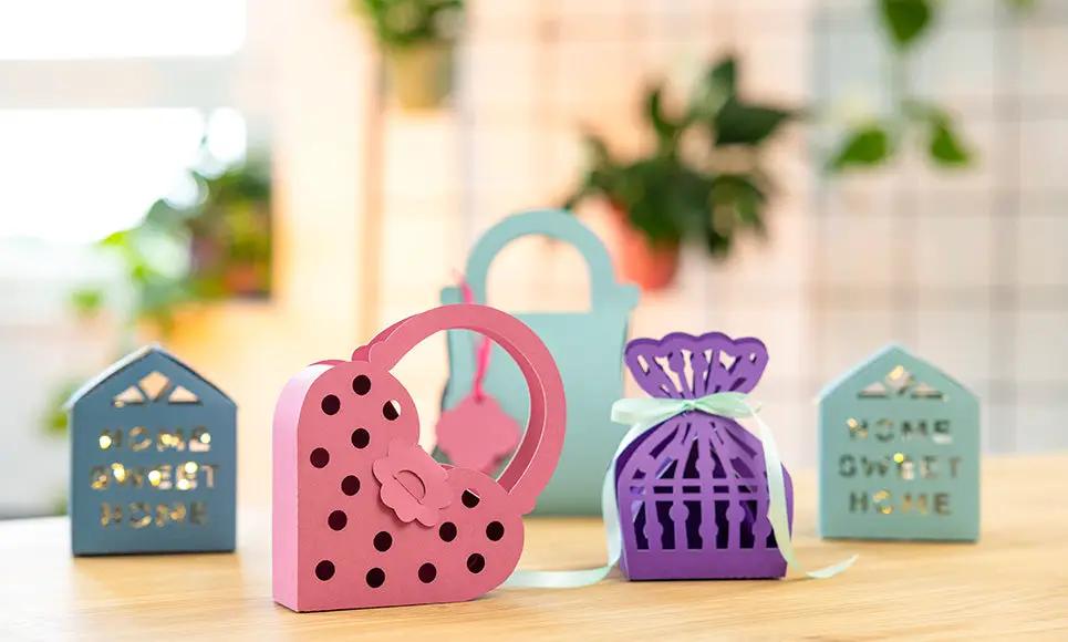 Brother Bellissimo CT1 Cutting Machine; display of 4 pastel cardstock shapes including pink heart and purple gift bag