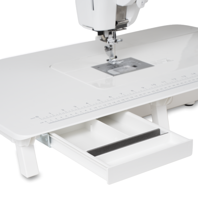 Janome Continental M6 sewing machine with white extension table and ruler, pull-out storage drawer.
