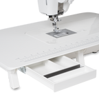 Janome Continental M6 sewing machine with white extension table and ruler, pull-out storage drawer.