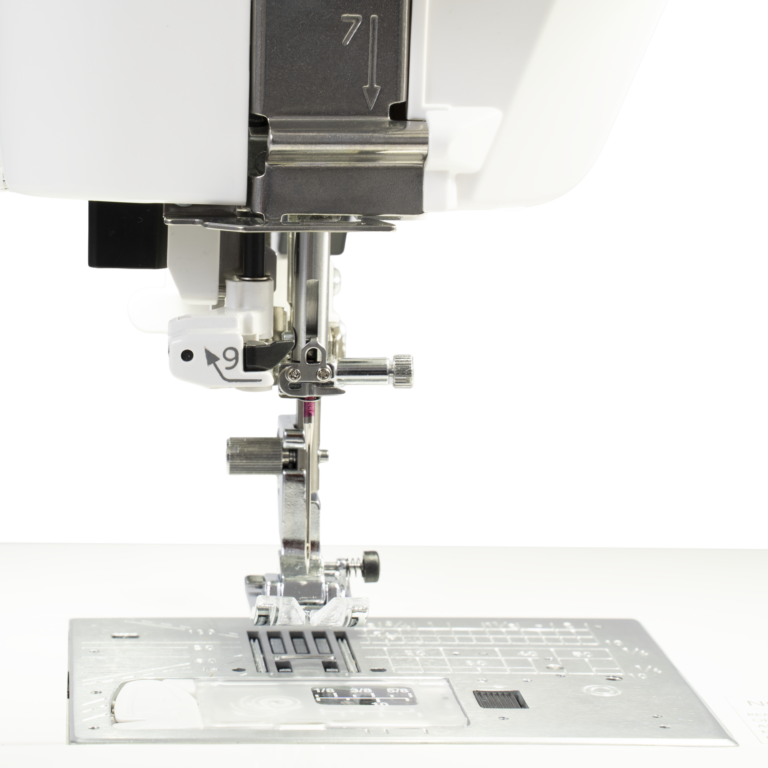 Janome Continental M6 sewing machine needle area with metal presser foot on the plate.