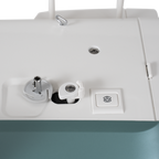 Janome Continental M6 sewing & quilting machine top view, white with teal base and visible bobbin area