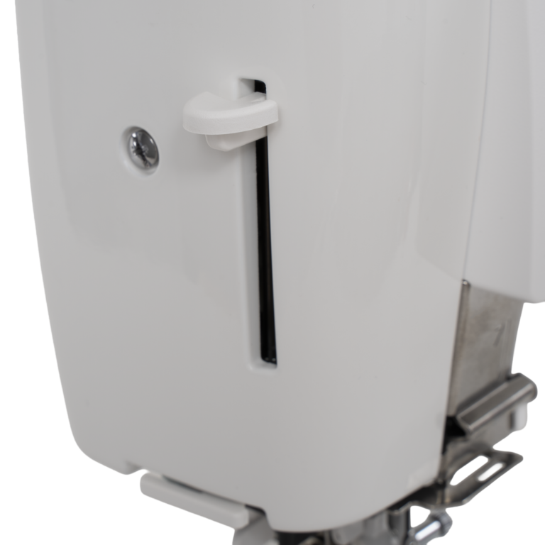 White sewing machine side panel with vertical tension slot and pedal visible