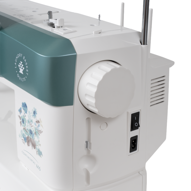 Janome Continental M6 sewing and quilting machine with teal front panel on white body