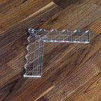 Handi Quilter dual-edge quilting ruler, clear acrylic L-shaped ruler with grid marks, on wood floor.