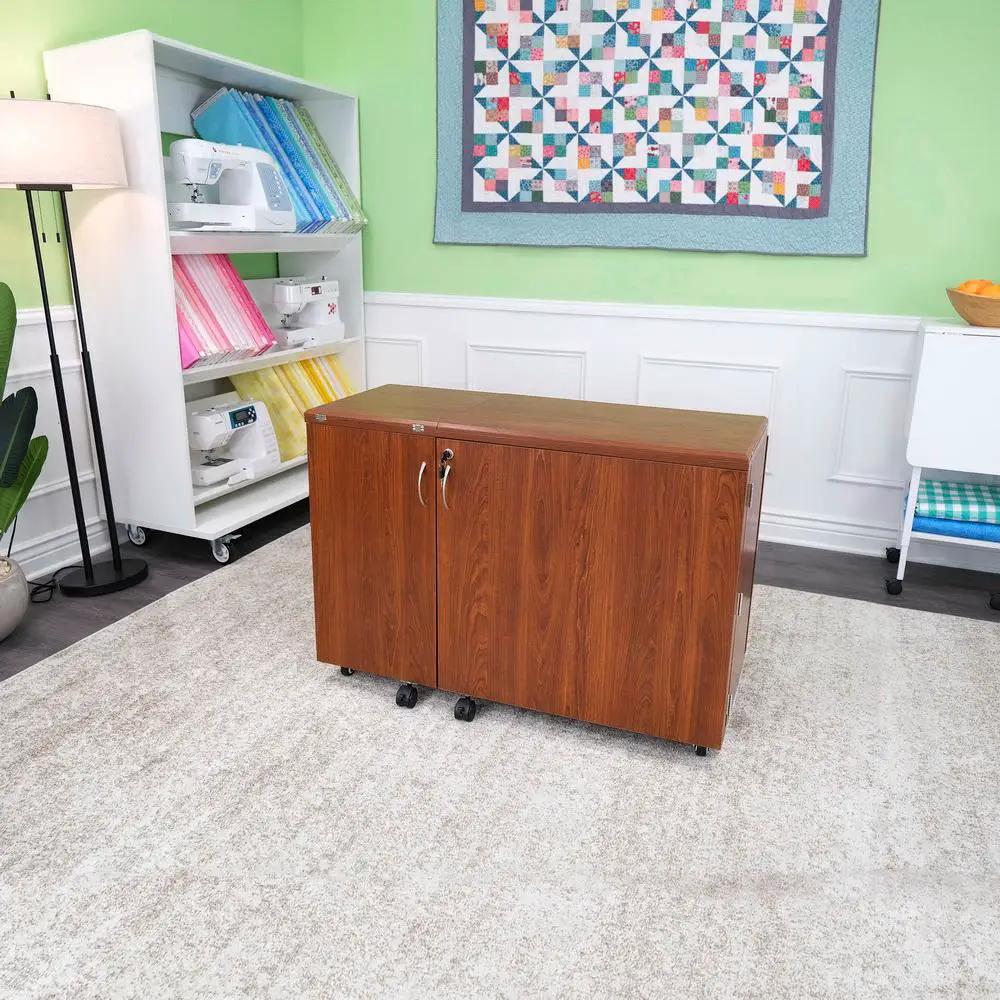 Kangaroo Sewing Furniture Wallaby II Studio air-lift sewing cabinet in teak finish on casters.