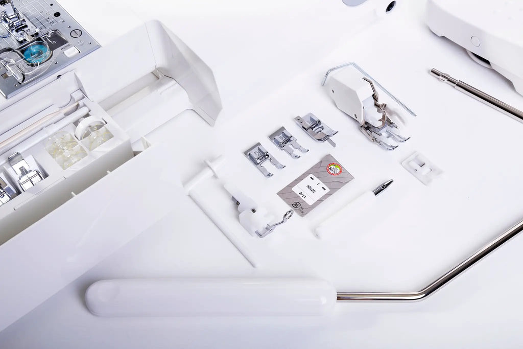 Juki HZL-DX7 white computerized sewing machine with assorted presser feet and accessories.