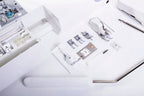 Juki HZL-DX7 white computerized sewing machine with assorted presser feet and accessories.
