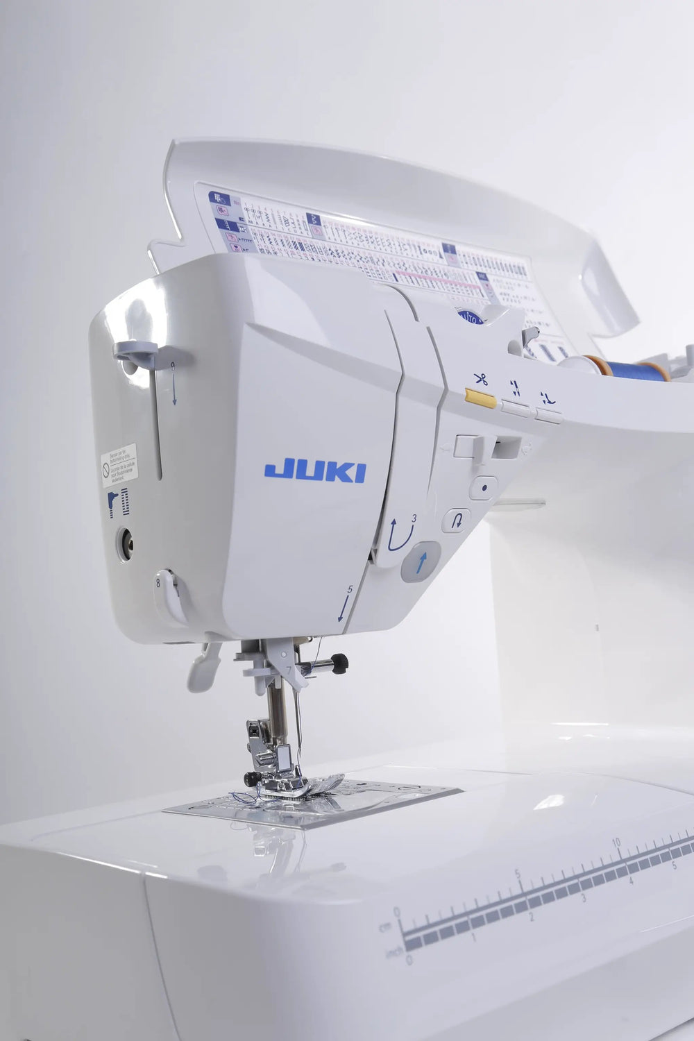 Juki HZL-DX7 sewing machine, computerized white unit with blue logo, side view.